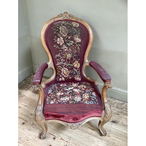 189 - A Victorian bleached walnut armchair having an encircling frame with foliate cresting, floral tapest... 