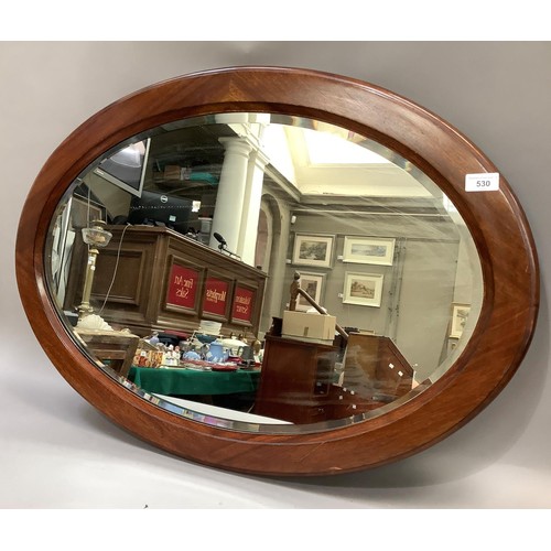 200 - An oval mahogany wall mirror with bevelled glass, 87cm by 64cm together with: After A.W. Brown, 'Pit... 