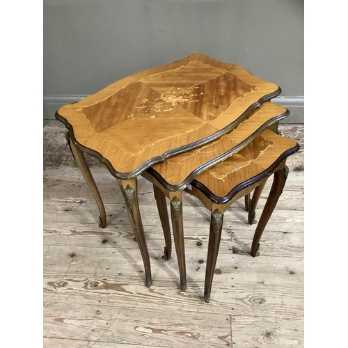 409 - A nest of three French kingwood quarter veneered occasional tables of rectangular serpentine outline... 