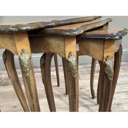 409 - A nest of three French kingwood quarter veneered occasional tables of rectangular serpentine outline... 