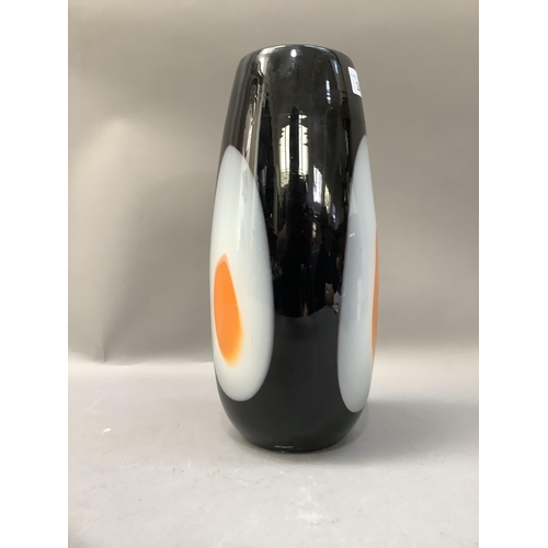 296 - A Studio glass vase of ovoid form, the black glass centred with a yellow and white egg type oval pan... 