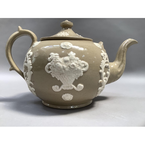 68 - A large stoneware teapot of buff colour, sprigged in white with basket of flowers and cartouche, 22c... 