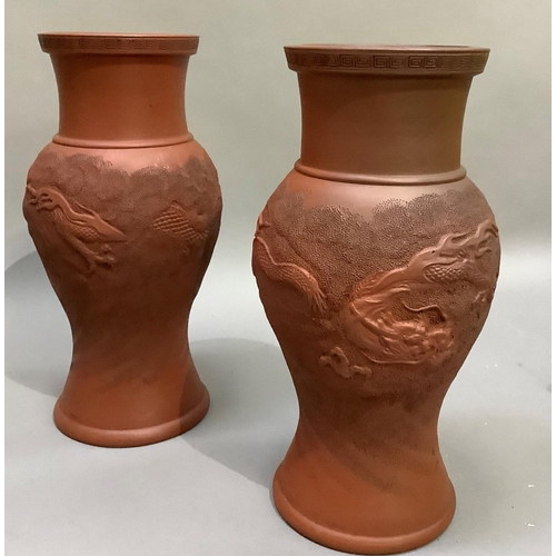 97 - A pair of Chinese red clay vases, the baluster bodies moulded with sinuous dragons, seal marks to un... 