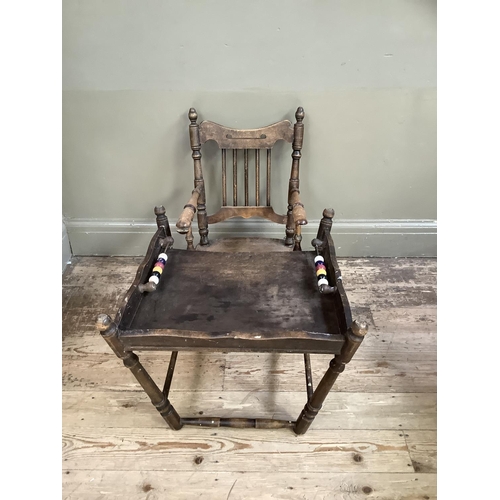 164 - An early 20th century child's high chair with rail back and turned framing, converting to a play cha... 