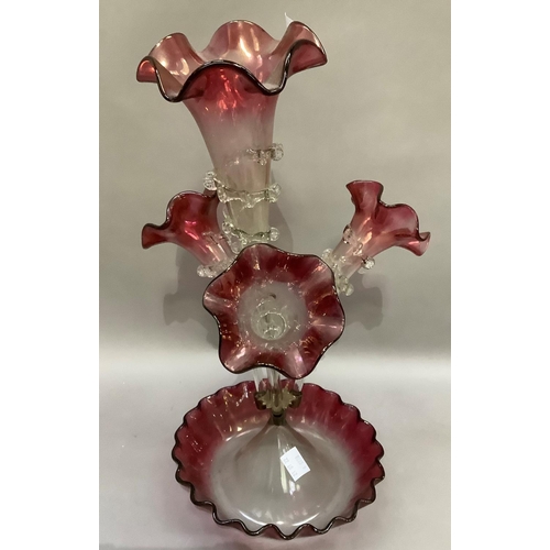 304 - A Victorian cranberry glass and clear four flute epergne with dished base, 49cm high