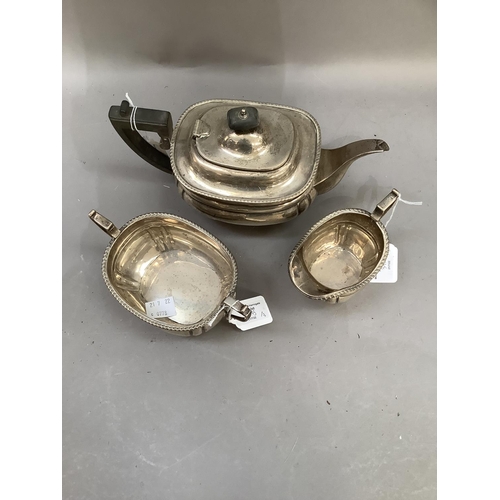 375 - A George V three piece silver tea service, oblong with gadroon rims and panelled body on ball feet, ... 