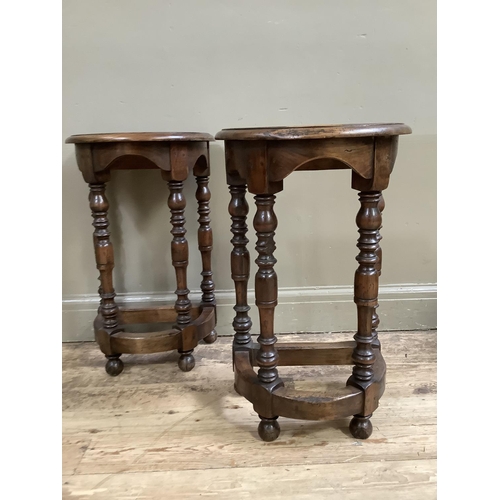 414 - A pair of reproduction fruitwood hall tables, demi lune, on four baluster turned legs joined by a st... 