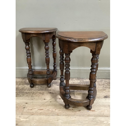 414 - A pair of reproduction fruitwood hall tables, demi lune, on four baluster turned legs joined by a st... 