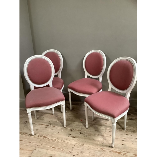 461 - A set of four ivory finished French style salon chairs upholstered in pink fabric to the oval backs ... 