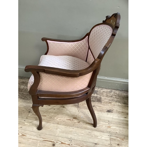 463 - An Edwardian walnut armchair having an encircling frame with arched cresting inlaid with ribboned fl... 