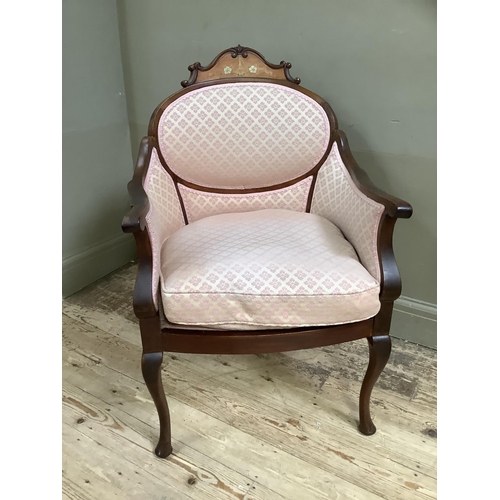 463 - An Edwardian walnut armchair having an encircling frame with arched cresting inlaid with ribboned fl... 