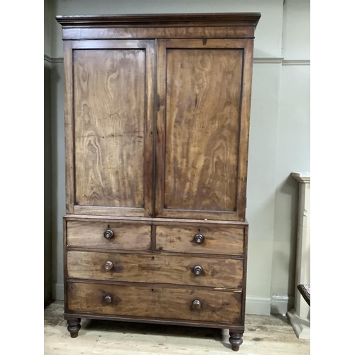 426 - An early 19th century mahogany clothes press having a moulded cornice above two indented panel doors... 