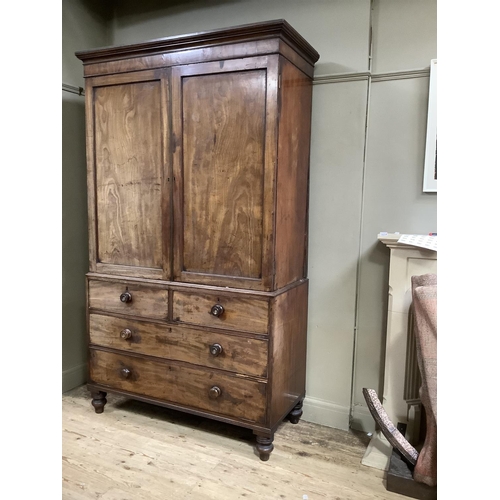 426 - An early 19th century mahogany clothes press having a moulded cornice above two indented panel doors... 