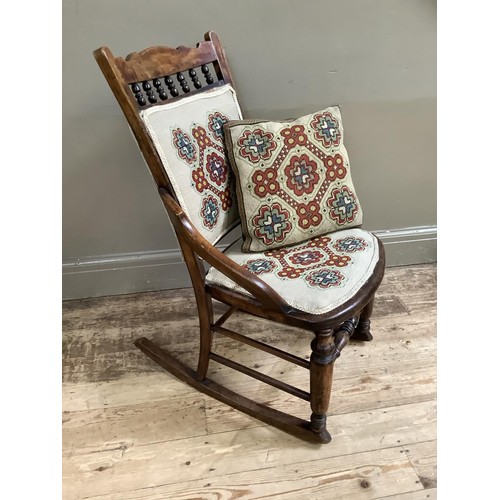 407 - A Victorian polished beech rocking chair spindle back with upholstered panel and seat, on turned fra... 