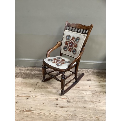 407 - A Victorian polished beech rocking chair spindle back with upholstered panel and seat, on turned fra... 