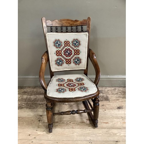 407 - A Victorian polished beech rocking chair spindle back with upholstered panel and seat, on turned fra... 