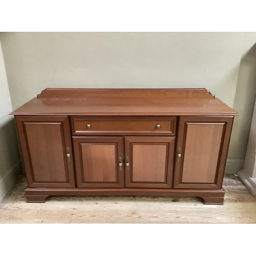 79 - A modern cherry wood finish sideboard having a drawer to the centre above two door cupboard flanked ... 