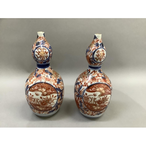 15 - A pair of late 19th century Imari double gourd shaped vases painted in under glaze blue, iron red en... 