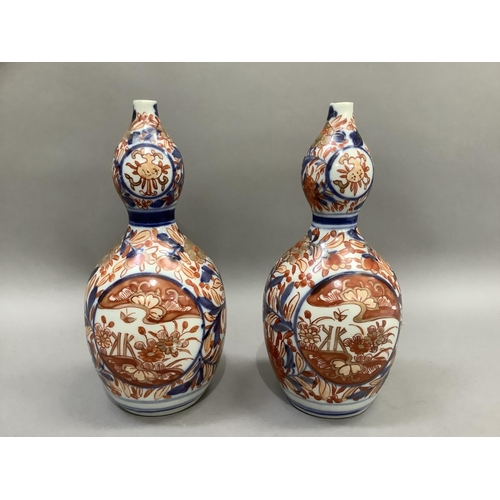 15 - A pair of late 19th century Imari double gourd shaped vases painted in under glaze blue, iron red en... 