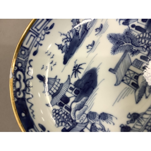 17 - A Chinese export blue and white cup and saucer painted with the willow pattern with gilt highlights ... 