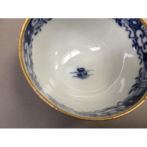 17 - A Chinese export blue and white cup and saucer painted with the willow pattern with gilt highlights ... 