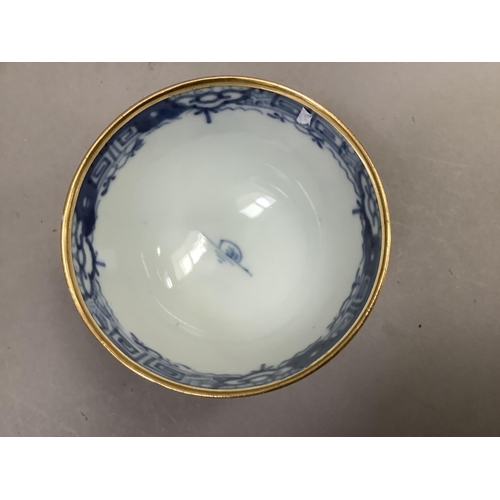 17 - A Chinese export blue and white cup and saucer painted with the willow pattern with gilt highlights ... 