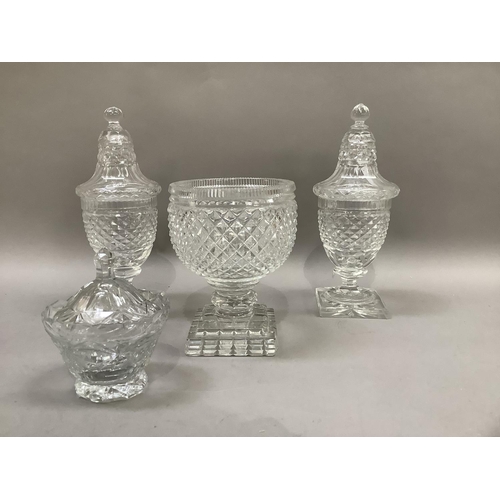 22 - A pair of cut glass bonbonnieres, the covers bell shaped with knopped finial on a panelled pedestal ... 