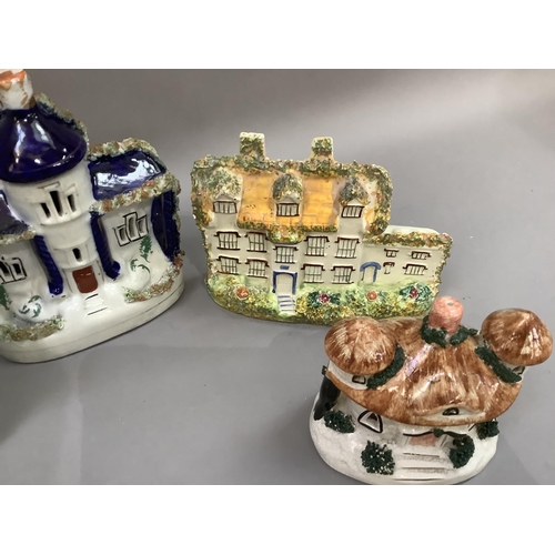 28 - A collection of early 20th century and later Staffordshire cottages, some as pastille burners