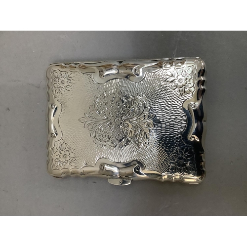 31 - An engine turned silver plated note/card case decorated with scroll work and a cartouche, with green... 