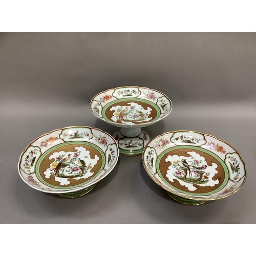 7 - An early 20th century continental china comport and pair of tazzas, circular with wavy rims, printed... 