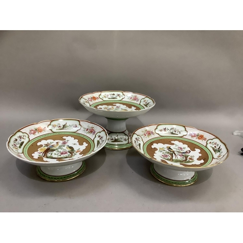 7 - An early 20th century continental china comport and pair of tazzas, circular with wavy rims, printed... 