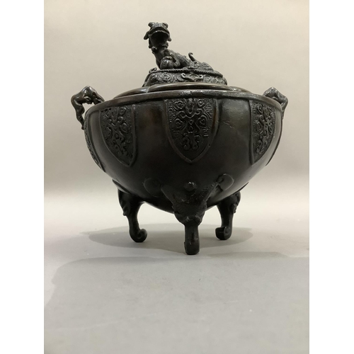 8 - A Chinese bronze koro of bowl form with twin handles, the cover with dog of Fo finial and on three e... 