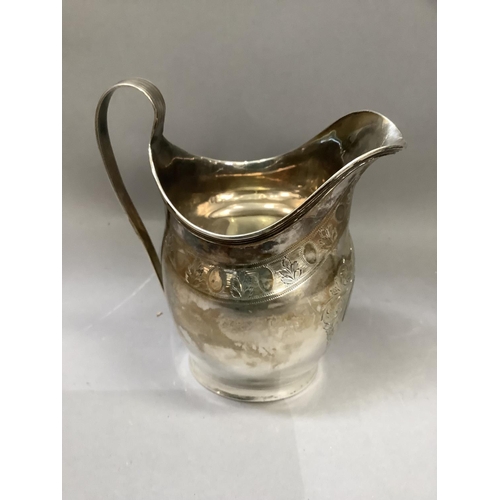 204 - A George III silver cream jug of helmet shape, bright cut engraved border of leaf and oval motif, in... 