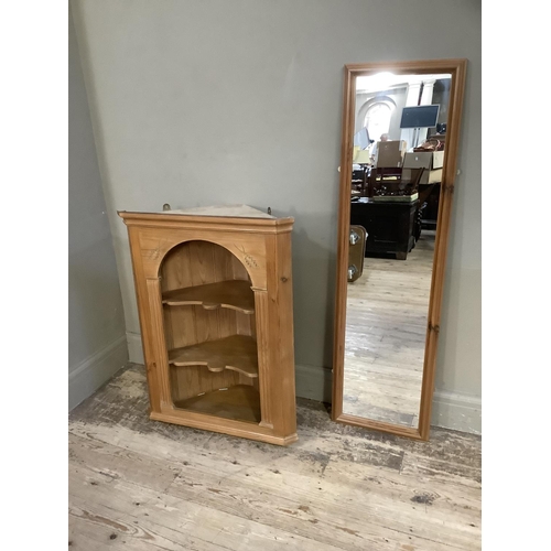 80 - A pine hanging corner cupboard with open serpentine fronted shelves together with a pine framed rect... 