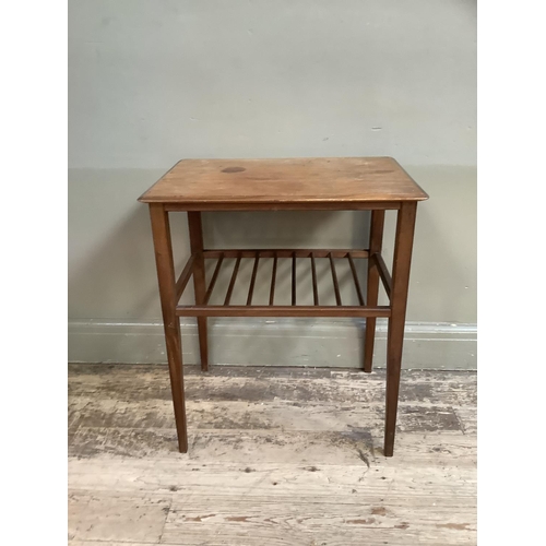 86 - An early 1970s teak occasional table, rectangular with railed undertier and on slender tapered legs,... 