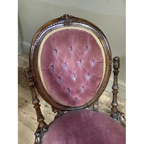 334 - A Victorian walnut nursing chair having a carved and moulded oval back with buttoned velvet upholste... 