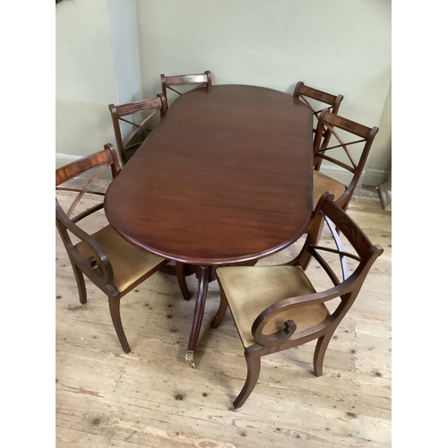 293 - A mahogany extending dining table, twin pedestal, brass paw feet and casters together with a set of ... 