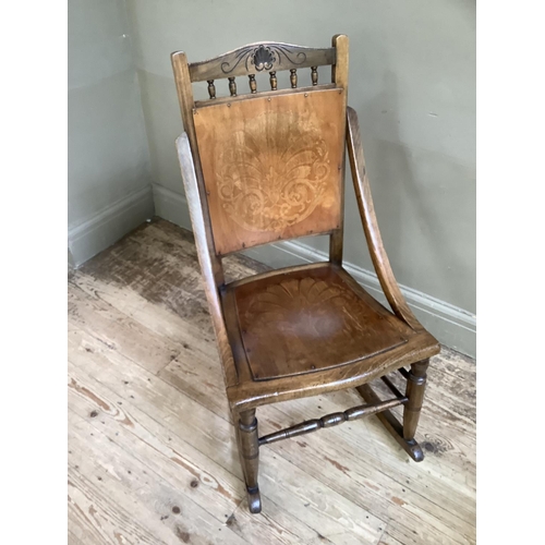 305 - A Victorian polished beech rocking chair with embossed panel for back and seat