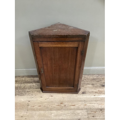 306 - A 19th century oak hanging corner cupboard with single indented panel door