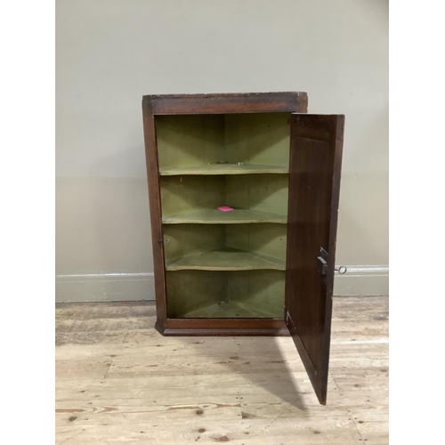 306 - A 19th century oak hanging corner cupboard with single indented panel door