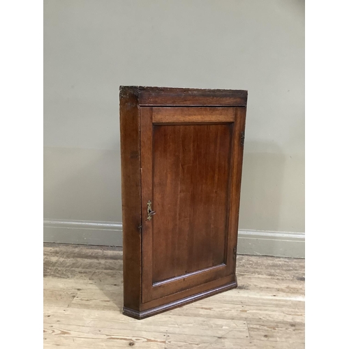 306 - A 19th century oak hanging corner cupboard with single indented panel door