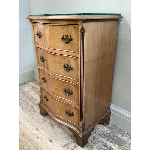 308 - A reproduction walnut dwarf chest of serpentine outline having four graduated drawers on bracket fee... 