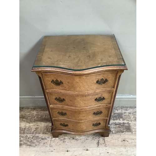 308 - A reproduction walnut dwarf chest of serpentine outline having four graduated drawers on bracket fee... 