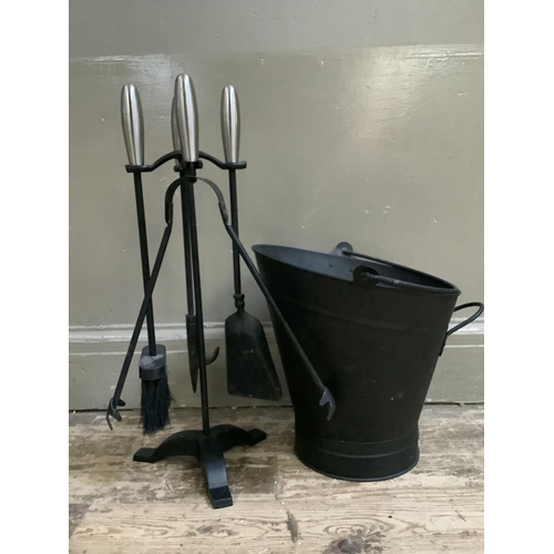 311 - A set of steel handled and black metal fire irons on a stand together with a matching coal bucket