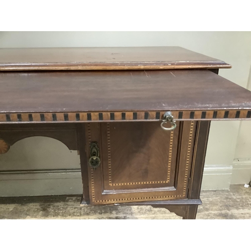 313 - An Edwardian mahogany and inlaid dressing table, the surface cross banded above a pull brushing slid... 