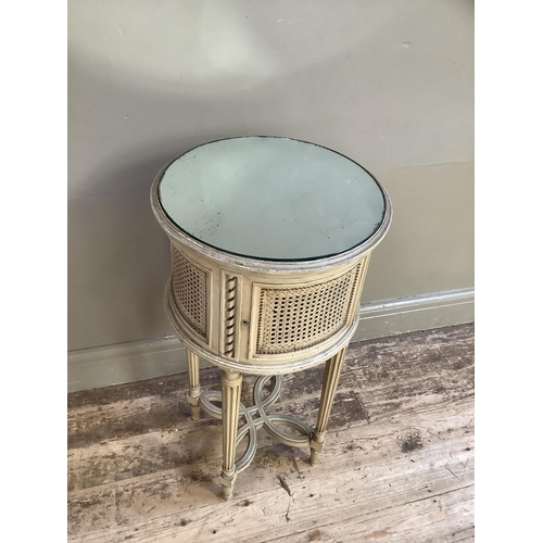 332 - A French style cream bergere caned drum bedside cabinet with mirrored top on fluted legs joined by a... 