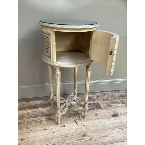 332 - A French style cream bergere caned drum bedside cabinet with mirrored top on fluted legs joined by a... 