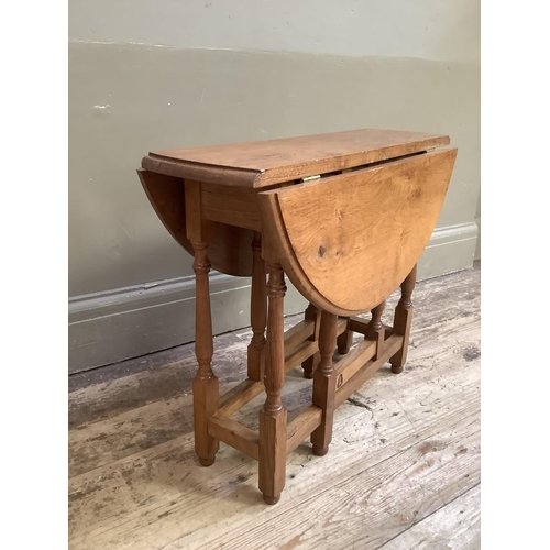 333 - A Yorkshire Carver oak gateleg occasional table having twin oval drop leaves on slender turned and s... 