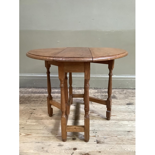 333 - A Yorkshire Carver oak gateleg occasional table having twin oval drop leaves on slender turned and s... 