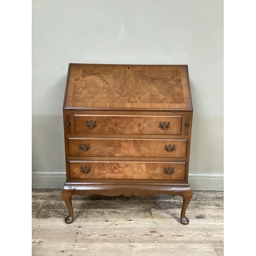 348 - A reproduction walnut bureau having a fall front with fitted interior over three drawers and on cabr... 